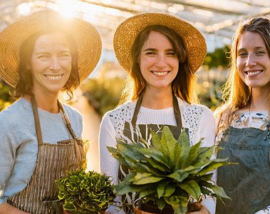 women history month: three women smiling holding their potted plants